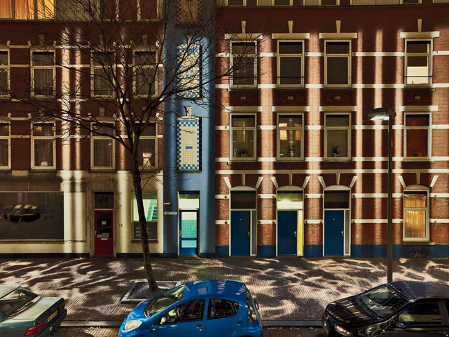 Shadow play Custom fixtures at the tops of the poles (Slide 3) face away from the street and house a series of mirrors and projectors that distribute a playful array of vertical and horizontal light p