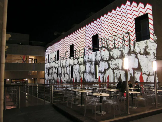 Modern art The herringbone-patterned elevations of Rafael Moneo’s Beirut Souks provide a textured canvas for a contemporary color interpretation of the lighting adjacent to a garden.