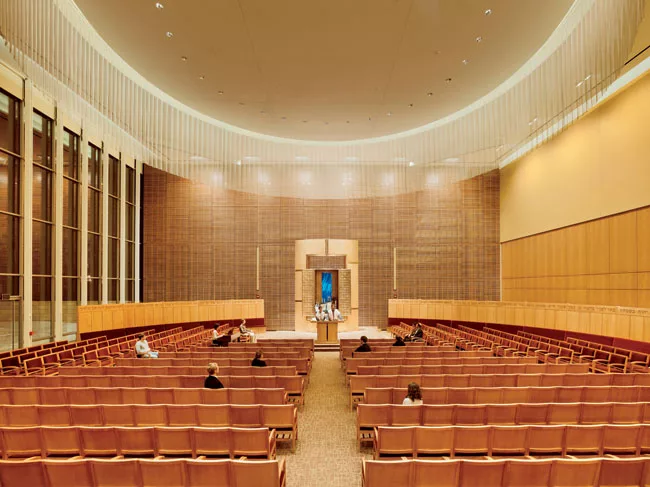 The architects and lighting designers collaborated to create a custom wood screen for the east-facing window wall behind the ark that delivers a subtle, filtered light during the day (slide 2) and an 