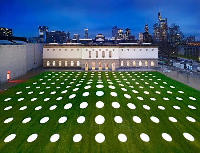 A mix of warm and cool LEDs in the skylights illuminate the grounds above the St'del extension in the evening.