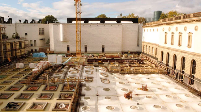 The free-form ceiling panels curve up to form a slight dome at the center.