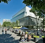 Wrapped in fritted, low-iron glass, the building is pristine by day, a serene backdrop for the pedestrian plaza, once a vehicular route.