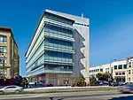 The offices are housed in a wedge that protrudes from the building's south side and wraps a corner. On the exterior of this glazed volume, a series of laminated glass shades directs and diffuses dayli