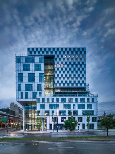 To connect these spaces, the architects created a central atrium with glazing on the north-south axis and fixed louvers on the south side (shown) to minimize heat gain.