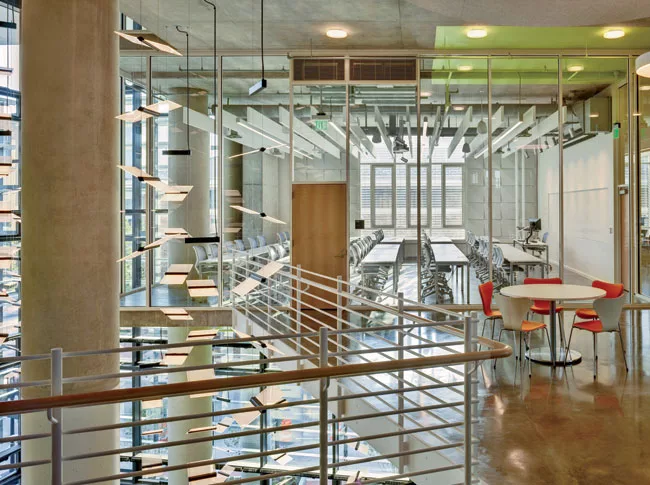Abundant glazing, such as for classroom walls, carries daylight into the interior. Still, the lighting designers created LED ceiling fixtures and chandeliers for evening hours and to illuminate darker