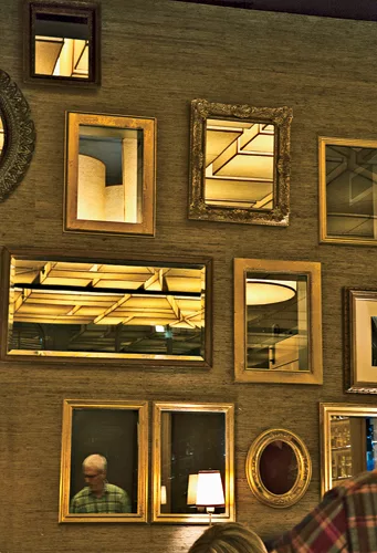The private dining area (slide 2) features a wall grid inset with a playful mix of mirrors and windows. These either reflect the barrel shades within the room or provide glimpses of the ceiling grid&m