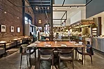 An exposed white kitchen spills into Saison&rsquo;s dining area (left). To minimize the room&rsquo;s height&mdash;which peaks at 30 feet&mdash;interior designer Jiun Ho suspended steel frames from the