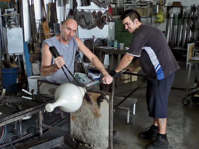 Glassblowers near Murano, Italy, work on early prototypes of the lamps.