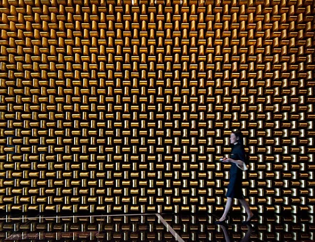 The lobby includes a 'gold bullion' wall of glass-fiber-reinforced gypsum created by interiors firm Tihany Design.