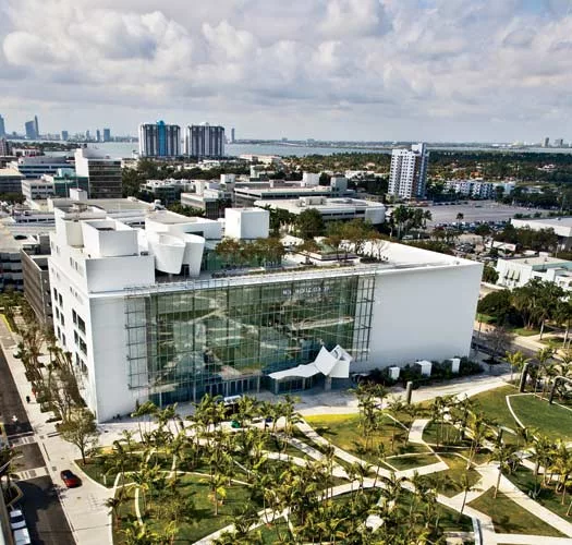 The center's entrance facade overlooks Miami Beach Soundscape, a park designed by West 8. To the side of the entrance is a 7,000-square-foot projection wall of smooth plaster on metal studs that displ