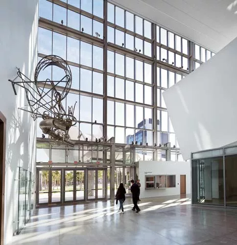 The atrium, featuring Frank Stella's bent tube sculpture Taboehan (2003), includes a lobby with a box office marked by a 17-foot-long plasma wall that announces the center's programs.
