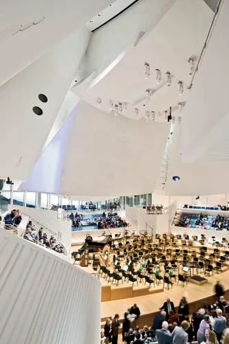 Daylight can enter the performance hall from the north window behind the 50-foot-high stage. 'Sails' of curved, layered drywall over 2-inch shotcrete create a surface mass and add to the luminous ambi