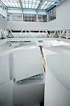 Fissures in the lids of the atrium's volumes containing chamber ensemble rooms allow daylight to filter from above to the interiors. 