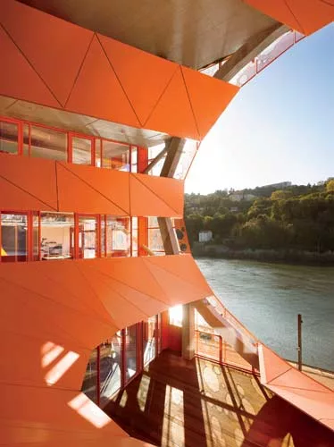 A faceted concrete frame supports the 43-foot-wide rim of a conical, west-facing void. Balconies look out toward the River Sa'ne.