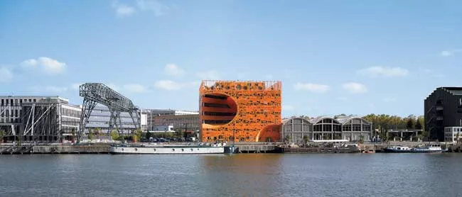 The budding 'Lyon Confluence' mixed-use district, which eventually will encompass 370 acres, features new and repurposed buildings. The curved void in the Orange Cube's lower southwest corner responds