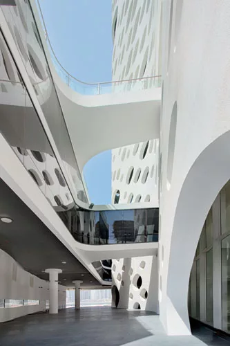The two-story elevated podium links to the concrete exoskeleton and the glass tower via bridges. The rear is open at the ground level to permit access to the plaza overlooking the bay.