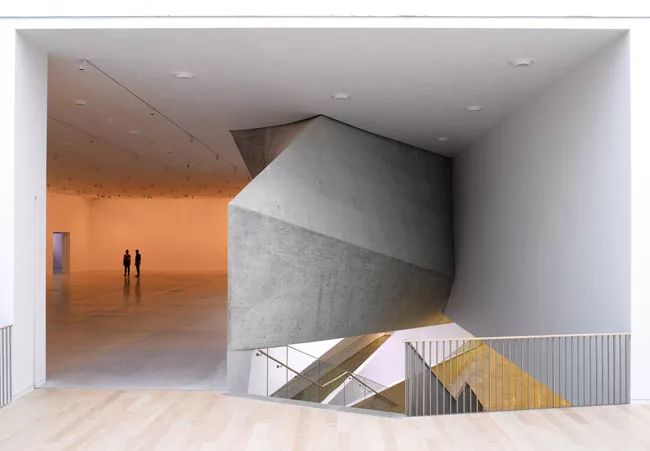 The plain, orthogonal galleries spiral around the Lightfall, which asserts its presence at certain places within the exhibition spaces.