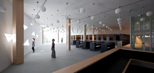 Tucked into the northwest corner of the addition, the library is the only space with columns and one of the few with generous glazing. A lower level provides more space for stacks.