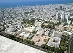 The new addition (seen as a rendered image in the photographic collage) stands across a small sculpture garden from the existing museum. It occupies a site within a larger complex of civic and cultura