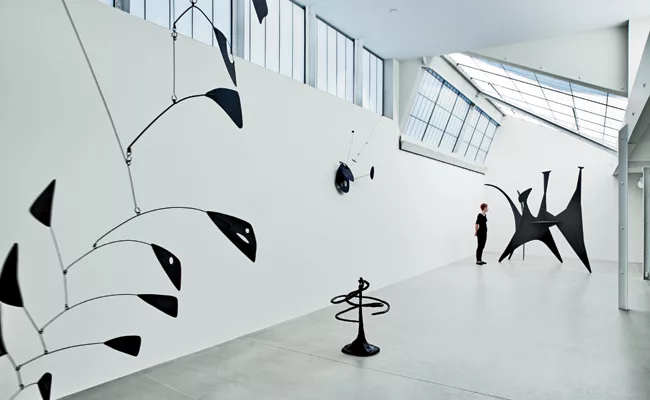 In renovating old roof sheds, Goto removed interior partitions and replaced wire glass with translucent sandwich panels, but kept the skylight angles and shed profiles. Original connections such as bo