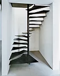 Inserted in a narrow space between two of the old sheds, a spiral stair leads to a small office for the foundation's president. Treads of 3/8-inch-thick blackened steel are attached to a 4-inch-wide s