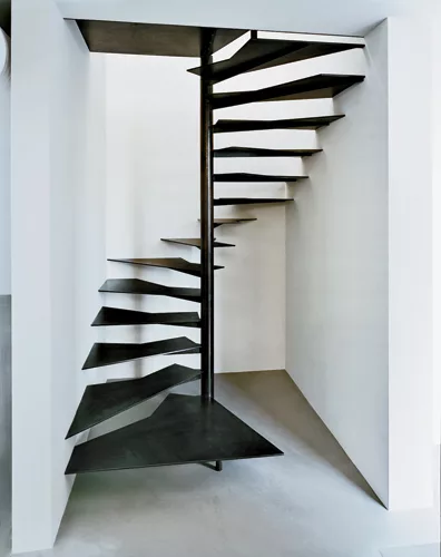 Inserted in a narrow space between two of the old sheds, a spiral stair leads to a small office for the foundation's president. Treads of 3/8-inch-thick blackened steel are attached to a 4-inch-wide s