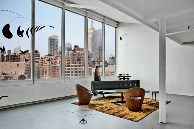 Large new windows orient a room to north light and views and provide a dramatic setting for a table by George Nakashima, wood chairs by Zanine Caldas, and a couch by Vladimir Kagan. Goto designed the