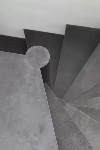 A new stair to a private office is made of raw steel and is the only new element that is not white or off-white.