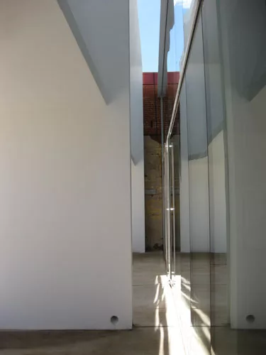 Original party walls are visible through the gap between the brise-soleil and the building facade.