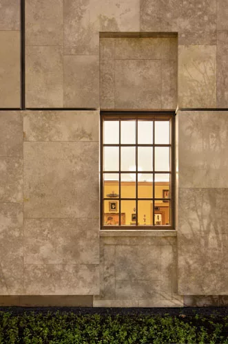 Seen from the Parkway facade, the rooms are framed within the wood-mullioned windows set in Negev limestone.