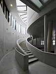 Some of the columns tilt in order to give the space a slightly less monumental air. The stairs swirl upward, with sidelights and top lights illuminating the space dramatically.