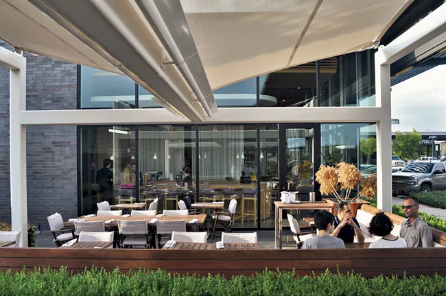Patrons enjoy a meal at the outdoor dining area of Matthew Kenney, a raw whole-foods restaurant.