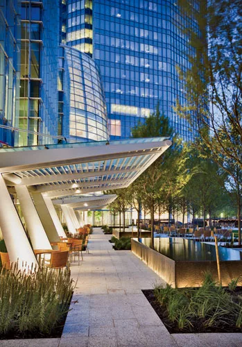 A canopy creates a transition between the café and seating area inside and a lush green space, which is used by Devon employees as well as the public.