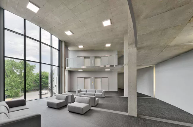 Double-height common rooms are meant to inspire a sense of community in the apartment buildings.
