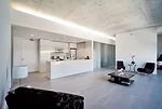 The exposed-concrete ceilings continue in the individual units. Services and mechanicals line one wall, freeing up the rest of the apartments for loftlike living. Partitions with sliding doors separat