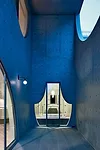 A playful, curtainlike window wall on the terrace relieves the concrete facade and frames views from the master bath.