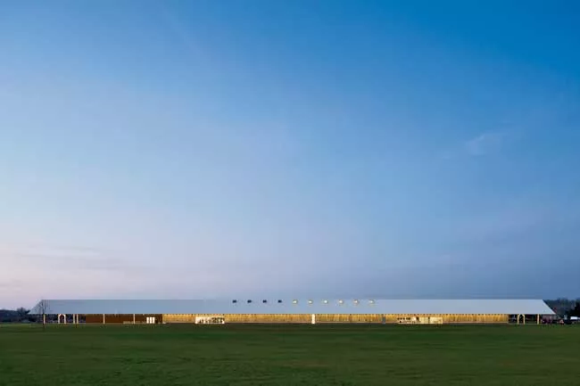 The designers placed the building near the center of a former agricultural site converted into a meadow. The grasses are intended to grow with minimal intervention, softening the view of the Parrish's