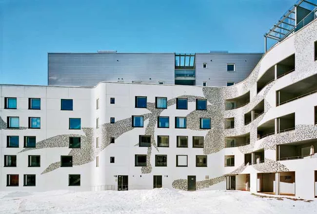 The bright colors of the waste-porcelain chips that make up the pattern on the building's curved white concrete facade were dictated by the production run at the local Arabia factory. The porc