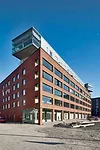  At street side, an arcade in the red-brick front gives the impression of a public building while protecting entrances to the private spaces