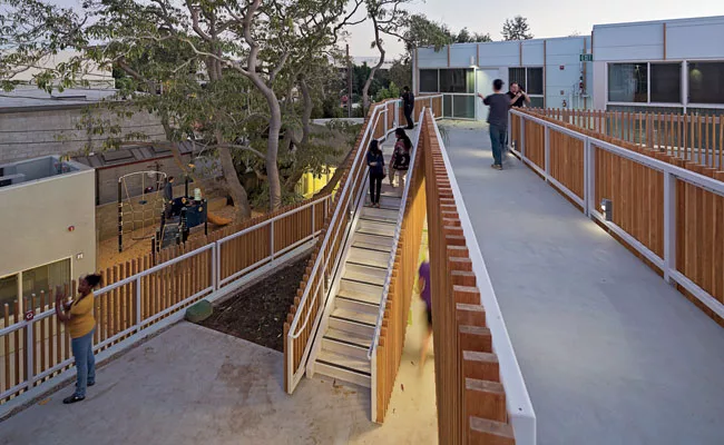 The complex's vertical circulation was configured to minimize the number of units passed en route to any front door. Small ancillary buildings (left in photo) house the laundry room and community spac