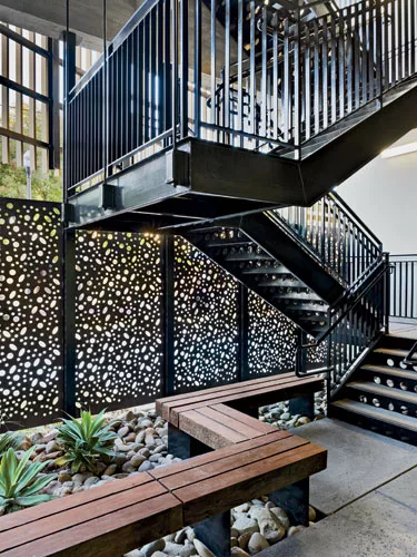 Water-jet-cut Cor-Ten steel with an ornate pattern enlivens balcony fronts and fencing.