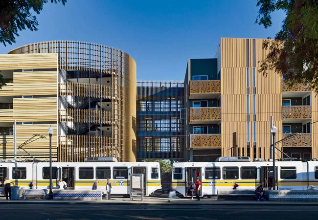 Built by Domus Development, the 63-unit structure is composed of two rectilinear blocks linked at the middle by an elevated-walkway system over a former alley. Recyclable polyvinylchloride siding shea