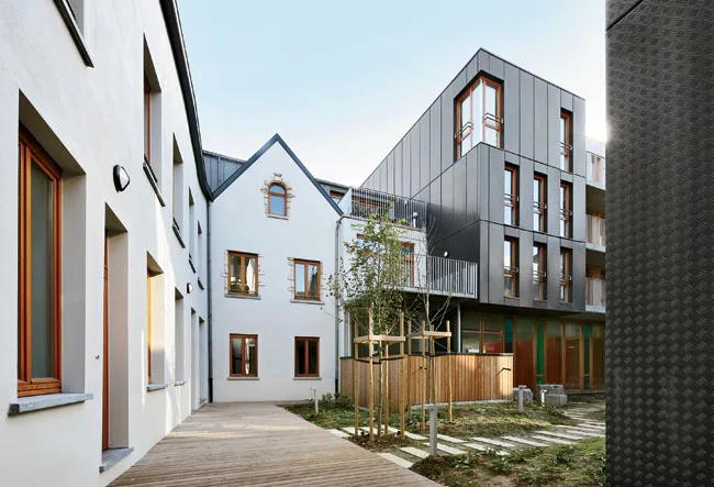 The architects renovated existing 18th- and 19th-century buildings into lofts and apartments, fusing them with new metal-faced dwellings and a colorfully glazed day-care center on a small garden or &l