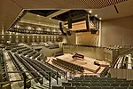 Asymmetrically arranged seating for more than 700 wraps the auditorium stage on four sides.