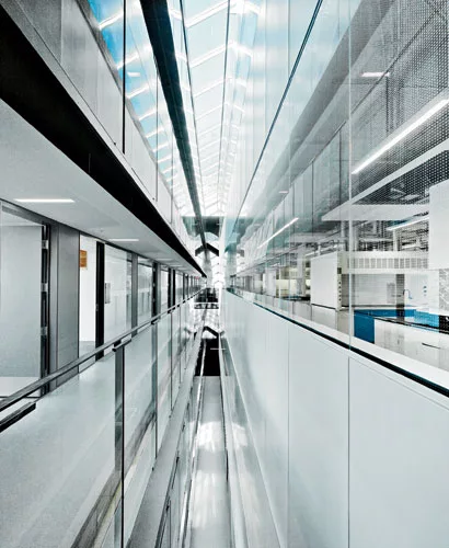 On the north edge of the sixth floor, a narrow skylit shaft brings natural illumination into the interior, separating the offices (banked on two levels) from the higher-ceilinged laboratories. The ski