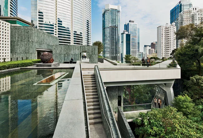 A pedestrian bridge links them to the new main pavilion on the lower site. On the pavilion's roof garden, visitors can enjoy an oasis in green marble amid skyscrapers and thick vegetation.