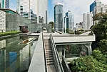 A pedestrian bridge links them to the new main pavilion on the lower site. On the pavilion's roof garden, visitors can enjoy an oasis in green marble amid skyscrapers and thick vegetation.