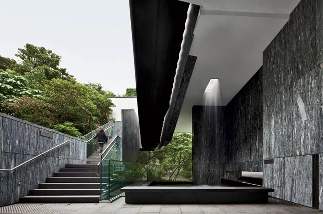 Striated Chinese-marble walls define the entrance as well as the lobby plaza on the east, where a waterfall cascades from the roof.