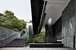 Striated Chinese-marble walls define the entrance as well as the lobby plaza on the east, where a waterfall cascades from the roof.