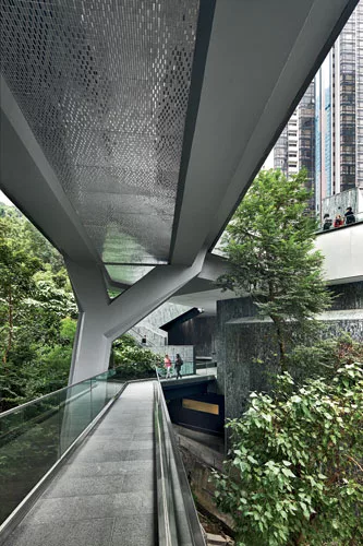 A double-level footbridge extends on the east from the roof garden of the new main pavilion and the plaza of the lobby level below. The walkway, marked by concrete Y-shaped supports, glazed ceramic ti